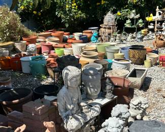 In the foreground, Asian style Buddhas, Foo Dogs, and pagodas and in the background a myriad of various planters and pots