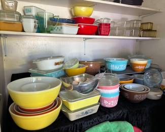 Lots of Pyrex glass kitchenware including bowls, casseroles dishes, and storage containers in various colors