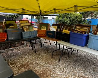 There are several bins of paintings, prints and frames