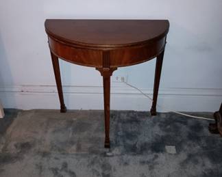 Half moon table , made of mahogany. That had a gate leg and opens up into round table. Very nice.