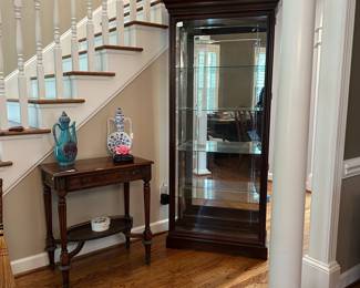 W65 - $400. Philip Reinisch Company lighted Curio Cabinet. Cherry Finish. Sheffield Collection. Measures 34.25" x 15" x 76.25"