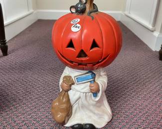 W131 - $35. Ceramic child with jack-o-lantern mask.
