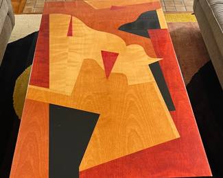 A striking one-of-a-kind tabletop by Benjamin Le for Axi Contemporary Furniture. This 20th-century piece features bold, geometric inlaid forms created with polychrome aniline-dyed woods in warm rust, ochre, black, and golden tones. The top is framed in a sleek black lacquered border, measuring approx. 64.75" L x 36.25" W x 2" D. A gallery-worthy surface that blends functional design with fine art sensibility—ideal as a dramatic table, desk, or wall-mounted installation.