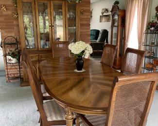 Nice dining room, table and chairs, and hutch full of dishes.