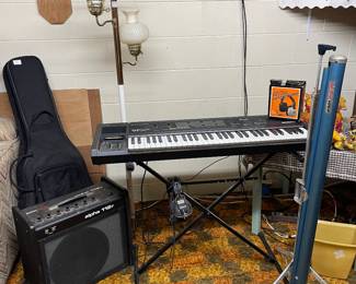 Keyboard, amp, guitar case, home movie screen