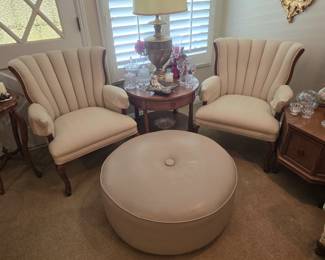 Large, taupe custom original rolling footstool, pair of custom upholstered channel back chairs, mid century end tables ans table lamps, crystal decor