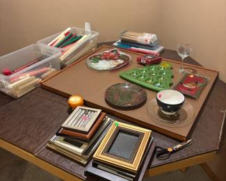 Tons of Christmas platters, frames, and boxes of tapers and candles.