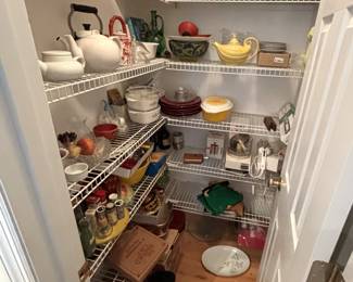 The pantry is packed with cookbooks, small appliances and clean cookware items.