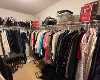 Closet is full of shoes, purses and ladies' clothing.