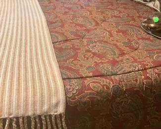 Beautiful comforter, pillow shames and dust ruffle on bed.