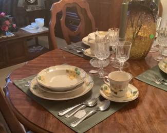 Dining table with China, placemats and center piece. The table measures: 62 1/2” long, leaf is 12” wide, width 40” wide, 29 1/2” from floor to table. Price for table and chairs is: 425.00