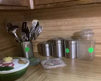 Stainless canisters and stainless container with kitchen utensils.