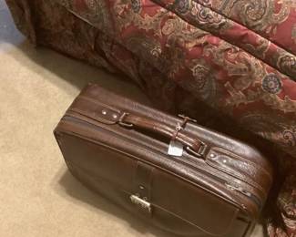 Suitcase at the end of the bed.