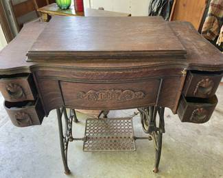 Foot powered antique sewing machine in a very nice wood cabinet.