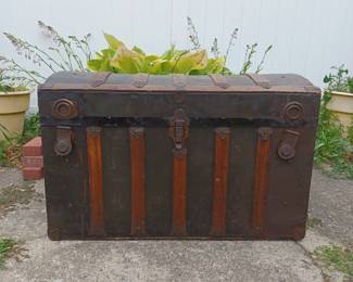 Very large steamer trunk with arched top and wooden accents. Three other trunks available.