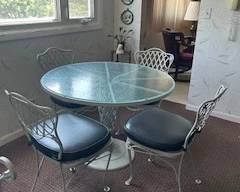 Heavy duty glass table and padded wrought iron chairs.  Immaculate condition.  Only used inside.  $ 250 for set