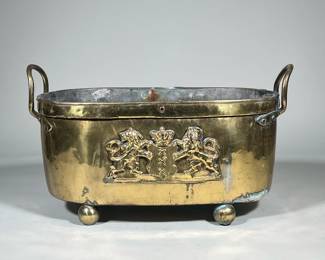 LARGE BRASS CACHETPOT LION INSIGNIA | Oblong cachetpot with balled feet and two handles. Raised lion insignia on front. - h. 12.5 x w. 11.5 x l. 20 in.