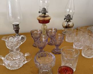 Kerosene lamps, cut glass tumblers, cut glass cream and sugar servers, cranberry glass tumbler