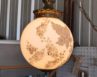 Pendant light with gold decoration on milk glass globe.