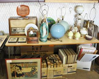German multi-band radio.  Features ability to operate on 110 or 220v power. Excellent collection of vintage lamps  including Aladdin Alacite, small floral decorated small Gone With the Wind lamp and cool Midcentury Modern lamps.  Over 100 piano rolls in boxes under the table.