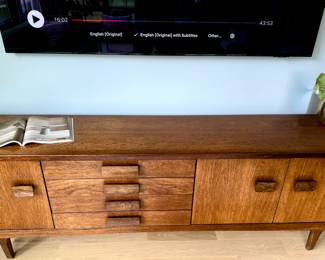MCM Circa 1960's Bath Cabinet Makers Sideboard.
Bath Cabinet Makers African Teak & Rosewood Sideboard, sold through Heals of London. 1960s.
Beautifully crafted piece comprising of one opening door to the left and two to the right revealing capacious interiors with adjustable shelving. Between these four drawers with a cutlery drawer. Furnished with beautiful curved solid rosewood handles. A quality piece of furniture.