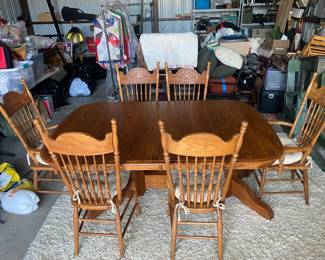 PRE-SALE item: An oak table with leaves inside the table.