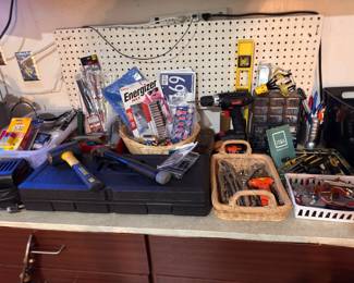 Workbench assortment of tools and hardware including wrenches, screwdrivers, pliers and power tool accessories