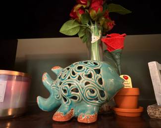 Turquoise ceramic elephant planter with ornate swirl design and small potted plant