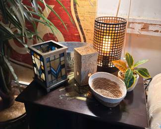 Wooden side table with wicker lantern and decorative bowls