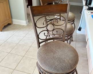 Three swivel metal padded counter height bar stools