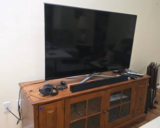 Nice 50" Flat Screen Smart TV on cabinet with pull outs on either side for dvd storage.  Blue ray disc player, Sound Bar, VHS tape player.