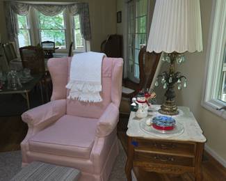 Pink easy chair with footstool.  Hollywood Regency marble top side table and fancy table lamp with crystals.