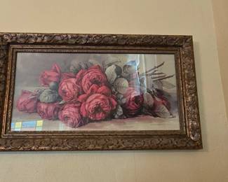 Framed antique roses print. This picture hangs to the left of the checkout table in the room to your right as you enter the house.