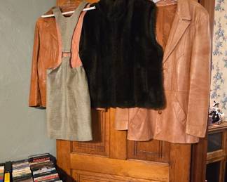 This room is just beyond the foyer and contains a table of movies, both vhs and dvd format. Hanging on the door is a fur vest, two vintage leather jackets and one groovy vintage lizard or snake skin jumper!