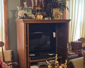 Coffee table is a charming, Shabby Chic-style, glass top, sage/mint green, low and round table on casters. There are seashells and a few pewter seashell bowls there on the coffee table.