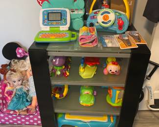 Toys are sitting on a substantial computer stand