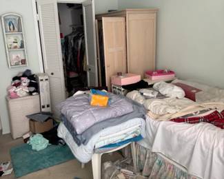 Bedroom filled with Women’s vintage clothing, shoes, antique hair rollers, mirrors, twin size bed frame, antique wooden desk, accessories, belts, more