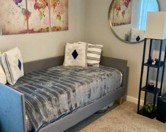 Daybed - Wall Art - Large Round Mirror - Shelving Lamp Decorative Throw Pillows and Bedding.