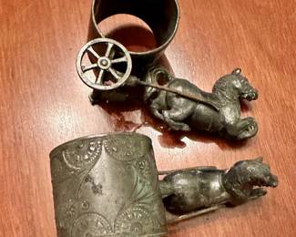 Silver horse napkin rings with rotating wheels. (Napkin ring on top has a broken wheel).