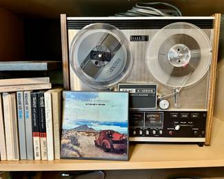 Teac reel-to-reel tape recorder with open reel tapes.