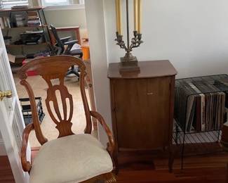Upholstered chair with decorative backing; music cabinet, fancy table lamp