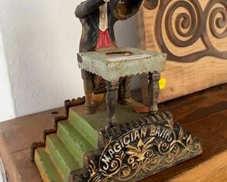 Vintage magician bank, cast iron. Put a coin on the table and watch him make it disappear!