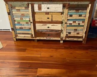 TV console, distressed multi-colored wood with 4 drawers and 2 side cabinets. Fashioned from various sources of repurposed wood. Measures 63" L x 36" H x 18" W. See next photo.
