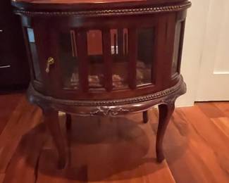 Chippendale style oval table with circumferential glass panels and front door for storage inside. Double table top with removable tray. Measures 29 H x 28" W x 19 "D