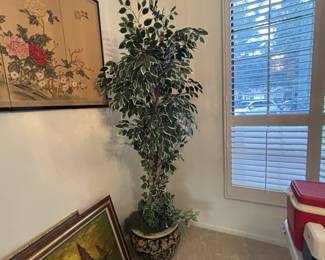 Paintings and artificial ficus tree in oriental pot.
