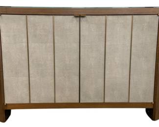 1759 - Wildwood Harper Console Brass spines surround doors of Shagreen leather inlay on the Harper Console. The faceted case, modern hardware, and clear glass top are the perfect composition of materiality, texture, and authenticity. This piece is finished on all sides and designed to float in a room when called for. 34 x 60 x 19
