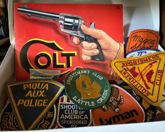 Vintage Colt Firearms book/manual; numerous vintage sportsmen’s club and hunting-related patches.