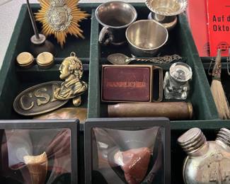 Extensive selection of interesting jewelry and smalls, including vintage sterling and silverplate cups, two Russian oil cans or weapon oiler bottles, a fossilized mosasaur tooth, a collection of German comedian Herbert Hisel EPs, and more.