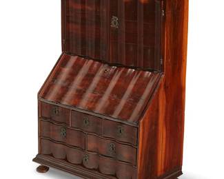 73
A miniature Dutch stained wood secretary
19th century
With a repeating serpentine front and a locking two-door cupboard above a slant front opening to reveal a fitted interior, above six drawers and a molded base, all raised on bun feet
35" H x 25" W x 14" D
Estimate: $500 - $800