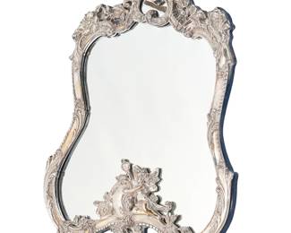 403
A Jack Rabinovich Rococo-style sterling silver-mounted table mirror
Late 20th century
Marked: JR [in a cartouche] © 925 / GR
With beaded accents, scrolled acanthus leaves, rocaille, and putti figures, mounted to a felt-lined wood easel back
22" H x 14.5" W x 1.75" D
Estimate: $700 - $900